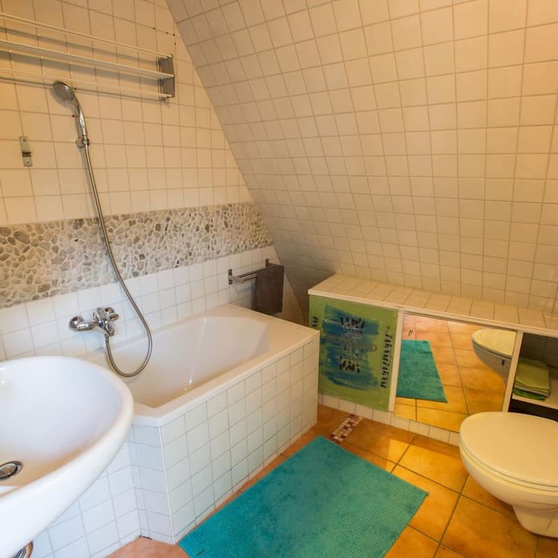Badezimmer mit Toilette und Spiegel.
