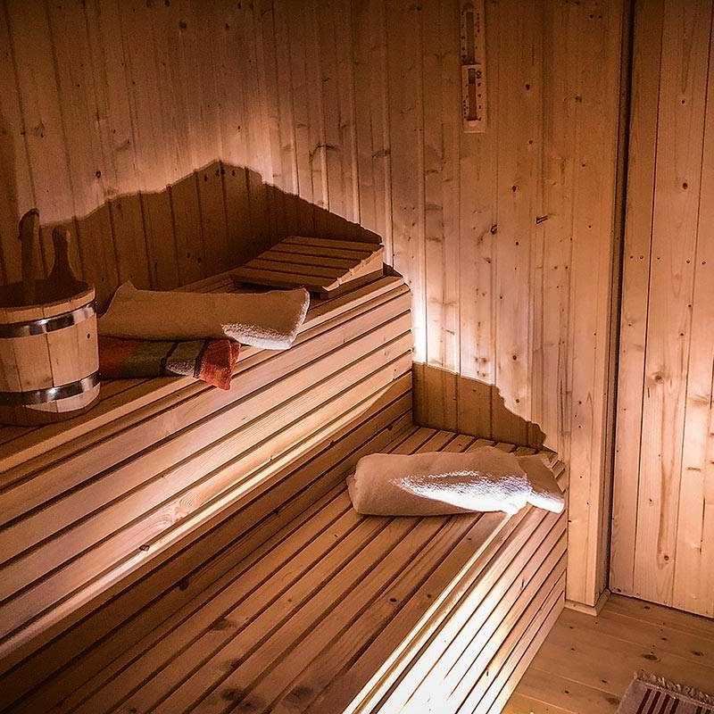 Die Sauna mit urigem Holzofen, Panoramafenster und angrenzendem Duschbereich ist eines der Hightlights.